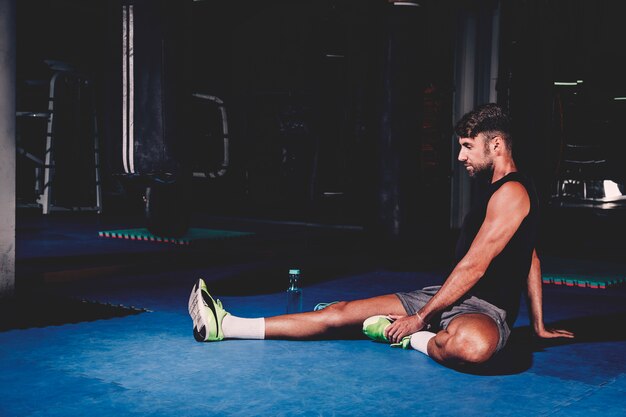 Hombre estirando en gimnasio