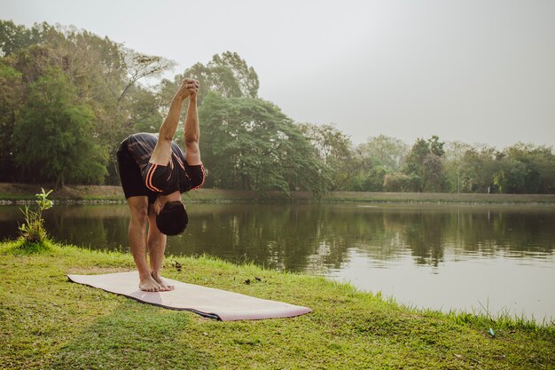 Hombre estirando, lago y naturaleza