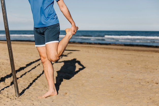 Hombre estirando en la playa