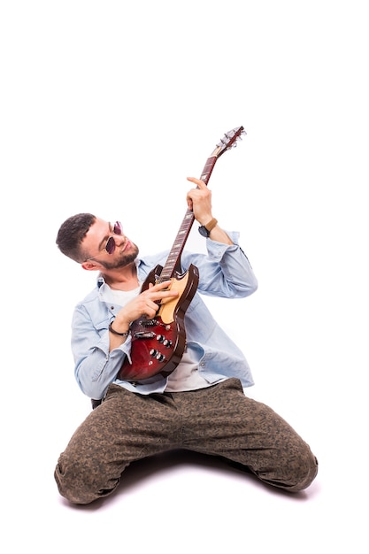 Hombre estrella de rock con una guitarra aislada sobre pared blanca