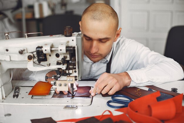 El hombre en un estudio crea artículos de cuero.