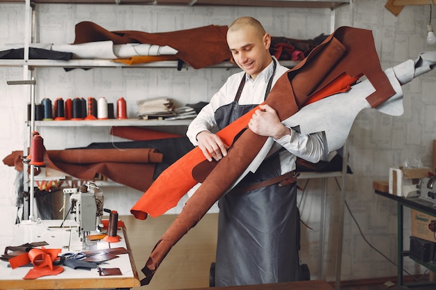 El hombre en un estudio crea artículos de cuero.