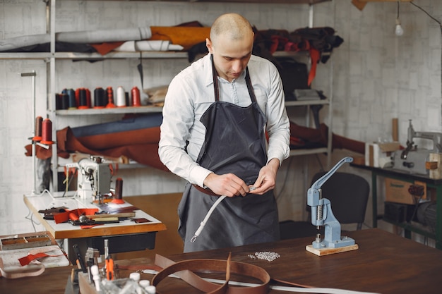 El hombre en un estudio crea artículos de cuero.