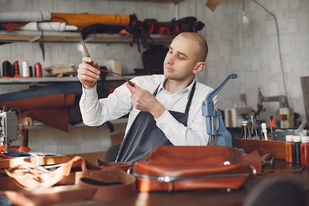 El hombre en un estudio crea artículos de cuero.