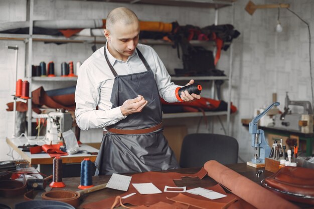 El hombre en un estudio crea artículos de cuero.