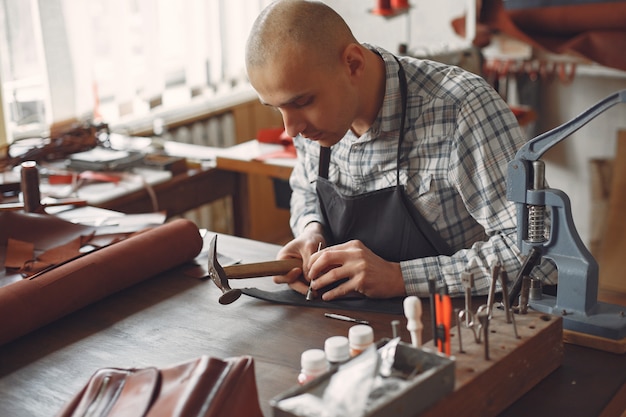 El hombre en un estudio crea artículos de cuero.