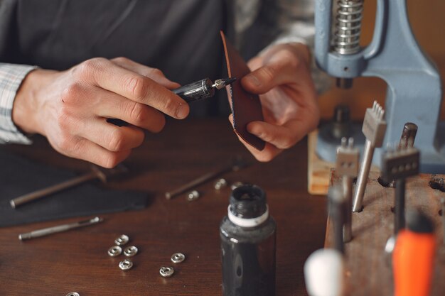 El hombre en un estudio crea artículos de cuero.