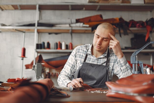 El hombre en un estudio crea artículos de cuero.