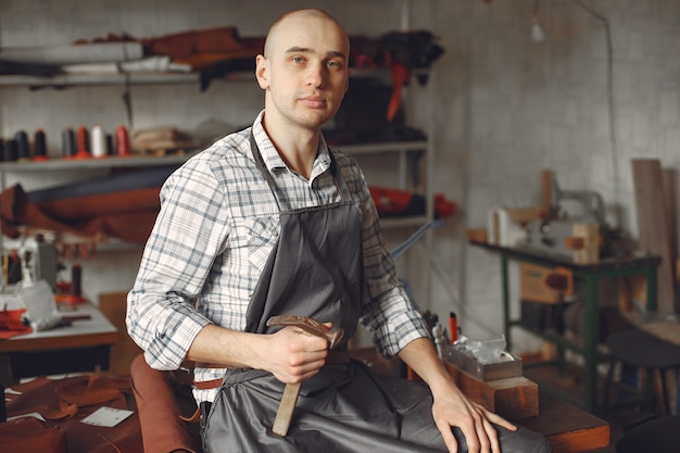 El hombre en un estudio crea artículos de cuero.