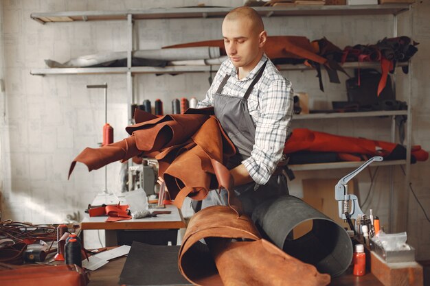 El hombre en un estudio crea artículos de cuero.