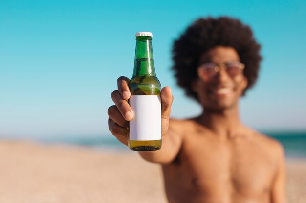 Hombre étnico sosteniendo una botella de cerveza