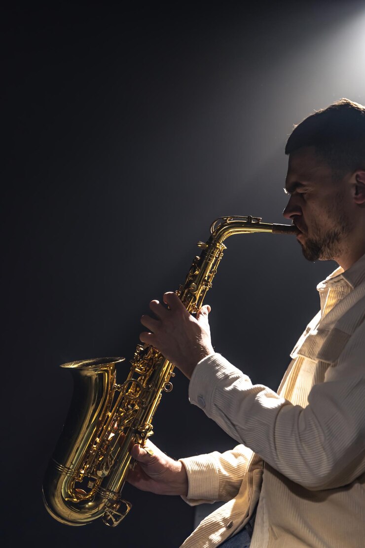 Foto gratuito un hombre europeo toca el saxofón en la oscuridad.