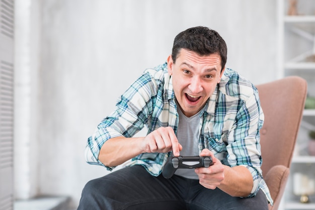 Hombre excitado jugando con gamepad en casa