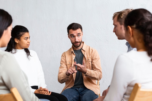 Hombre explicando sus problemas en una sesión de terapia de grupo