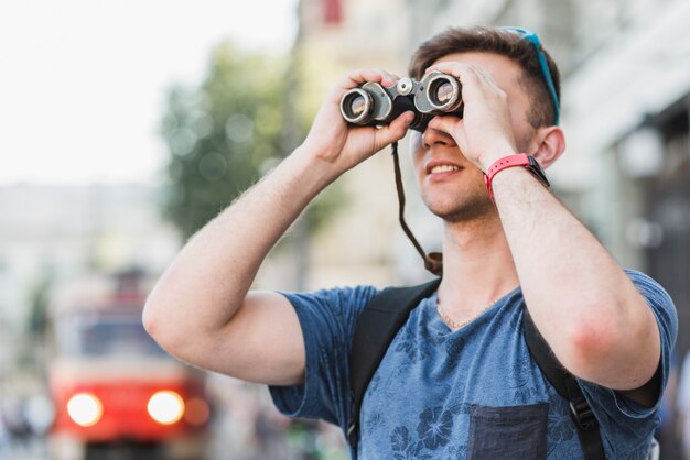 Hombre explorando la ciudad con binoculares