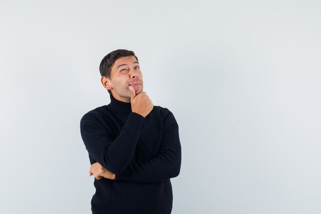 Un hombre expresivo está posando en el estudio.