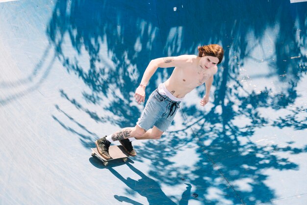 Hombre extremo sin camisa en patineta