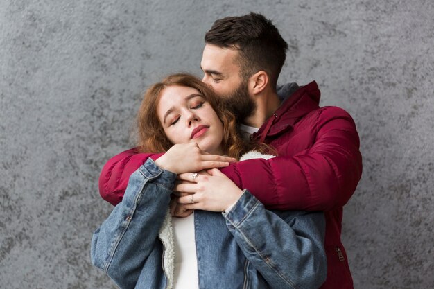 Hombre feliz abrazando a su novia encantadora