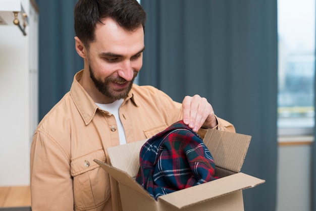 Foto gratuita hombre feliz abriendo pedido en línea