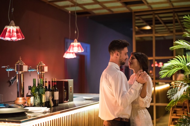 Foto gratuita hombre feliz bailando con mujer alegre cerca de barra de bar