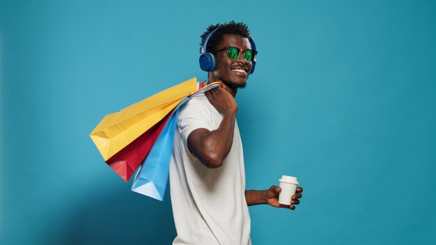 Hombre feliz con bolsos bailando después de la juerga de compras