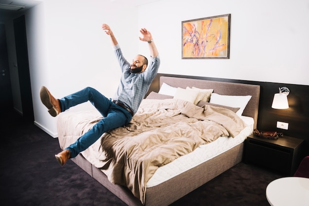 Foto gratuita hombre feliz cayendo en la cama