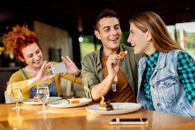 Hombre feliz compartiendo postre con su novia en un café