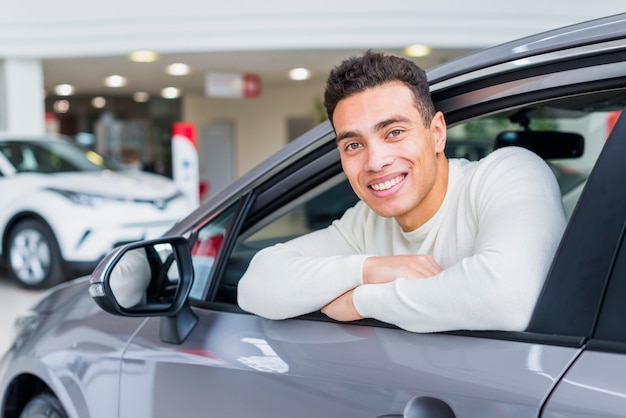 Hombre feliz en concesionario de coches