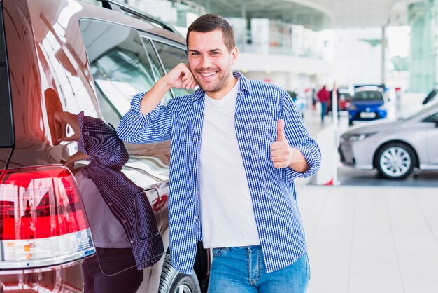 Hombre feliz en concesionario de coches