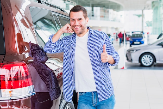 Hombre feliz en concesionario de coches