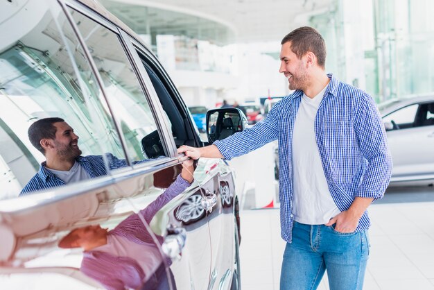 Hombre feliz en concesionario de coches