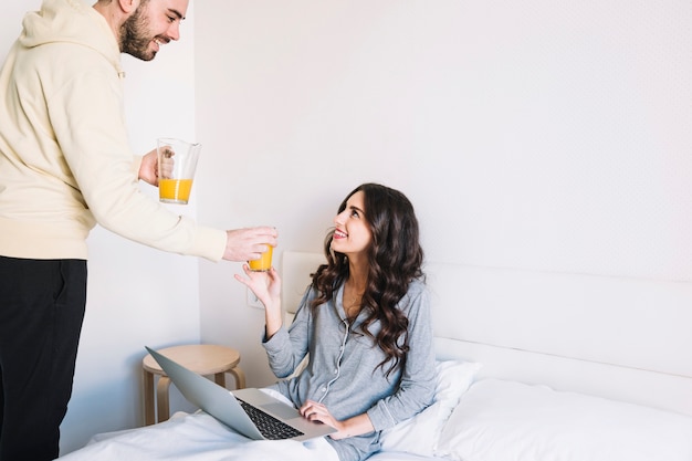 Foto gratuita hombre feliz dando jugo a la mujer