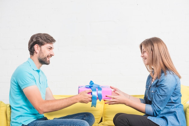 Foto gratuita hombre feliz dando presente a su encantadora novia