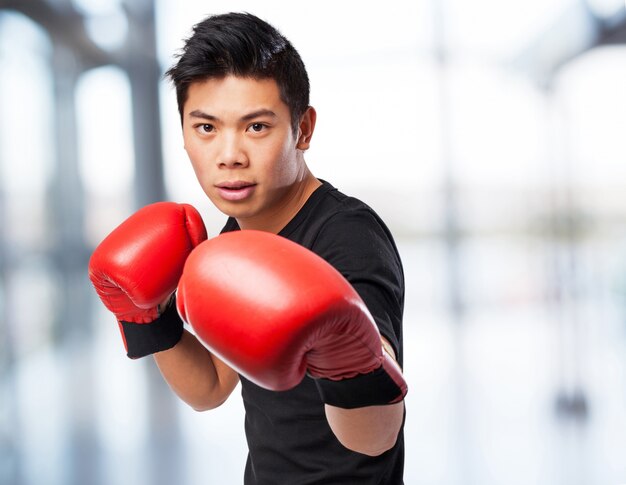 hombre feliz deporte chino con guantes de boxeo