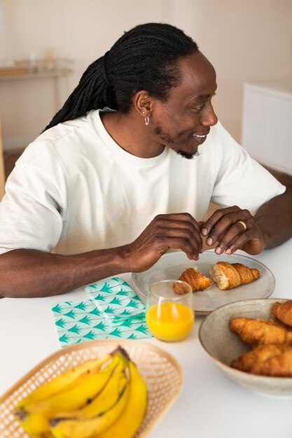 Hombre feliz desayunando con plátanos