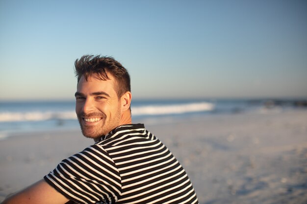 Hombre feliz descansando en la playa