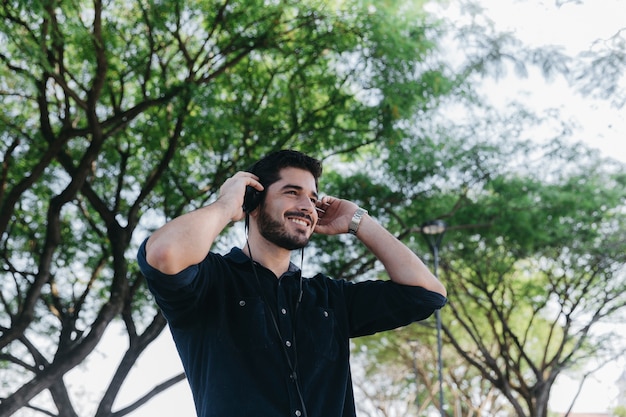 Hombre feliz escuchando música en el parque