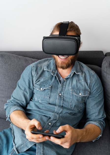 Foto gratuita hombre feliz con gafas vr en sofá