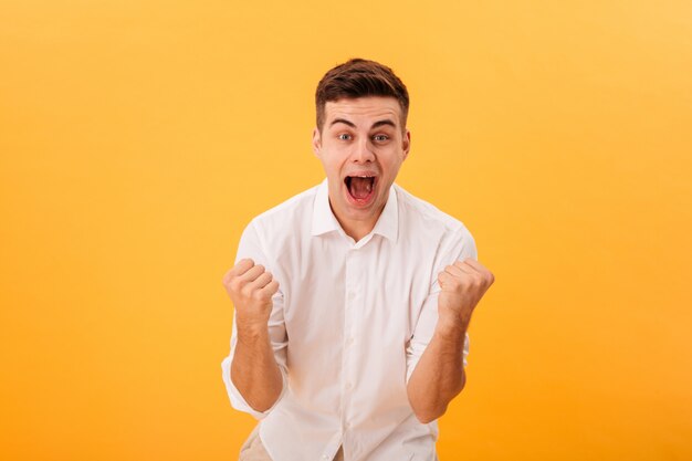 Hombre feliz gritando en camisa blanca se regocija