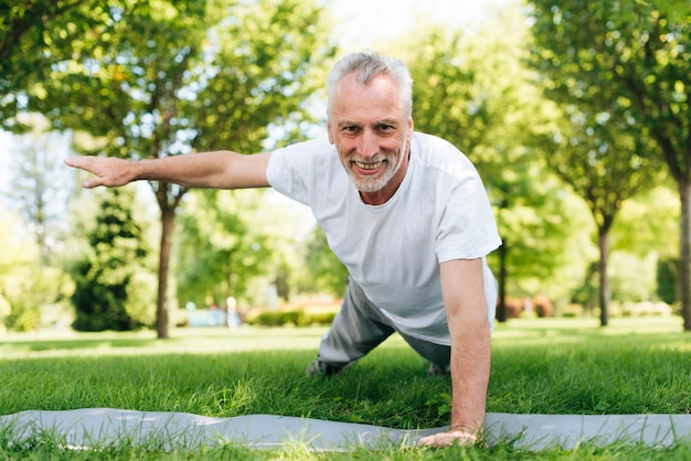 Foto gratuita hombre feliz haciendo flexiones en la naturaleza