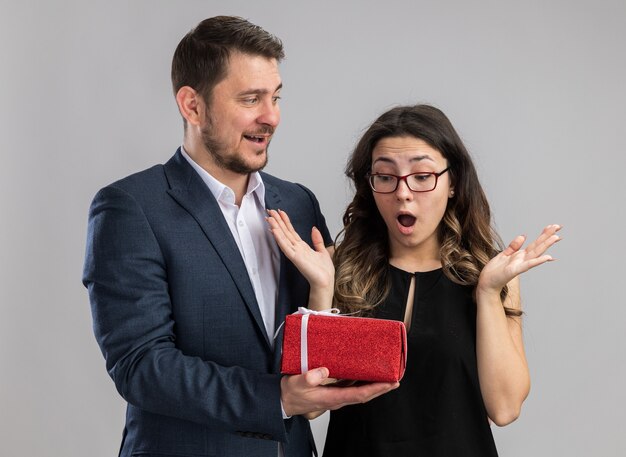 Hombre feliz joven hermosa pareja dando un regalo para su encantadora novia emocionada feliz en el amor juntos celebrando el día de san valentín