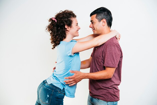 Hombre feliz joven que abraza a la mujer sonriente