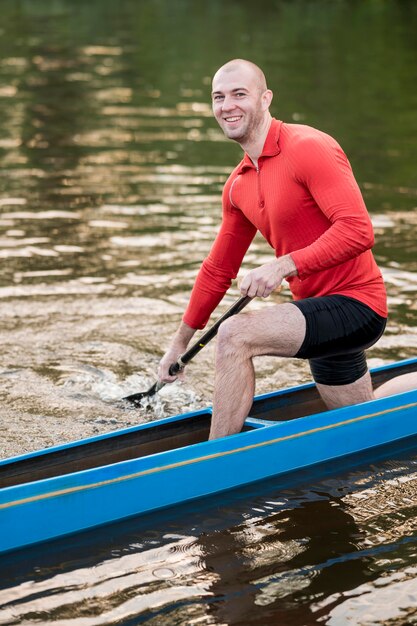 Hombre feliz en kayak azul