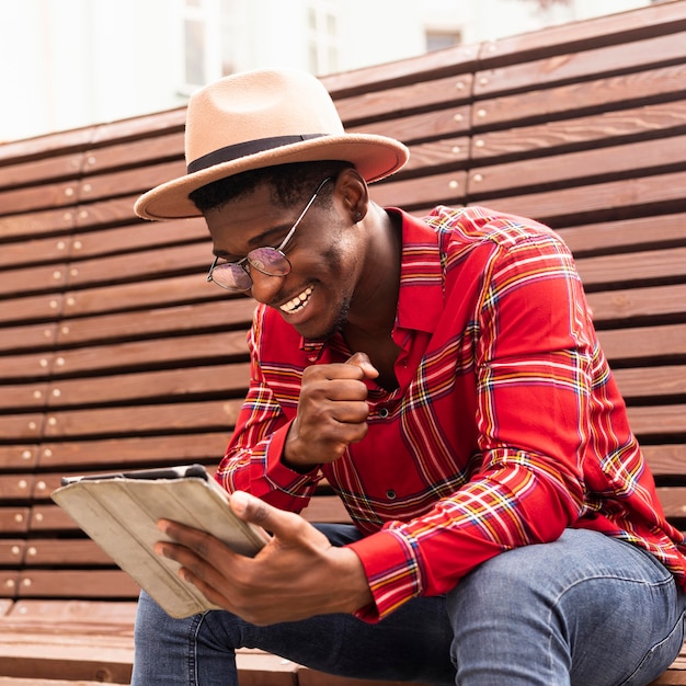 Hombre feliz leyendo desde su tableta digital