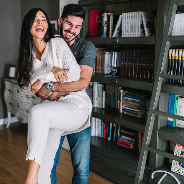 Foto gratuita hombre feliz llevando a su novia en casa