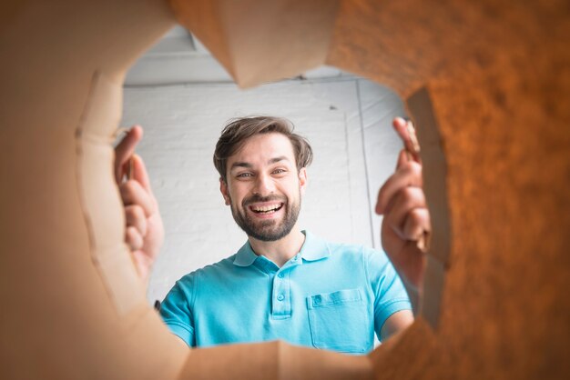 Hombre feliz mirando dentro de la bolsa de papel