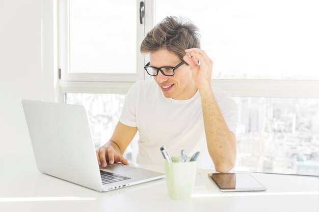 Hombre feliz mirando la pantalla de la computadora portátil