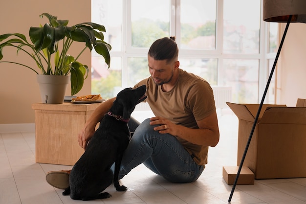 Foto gratuita hombre feliz mudándose a su nuevo hogar con su perro