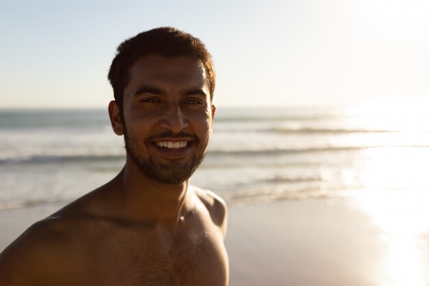 Hombre feliz de pie en la playa