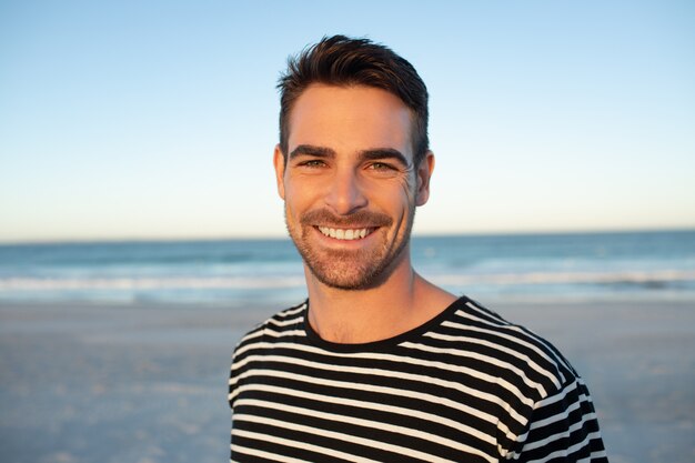 Hombre feliz de pie en la playa